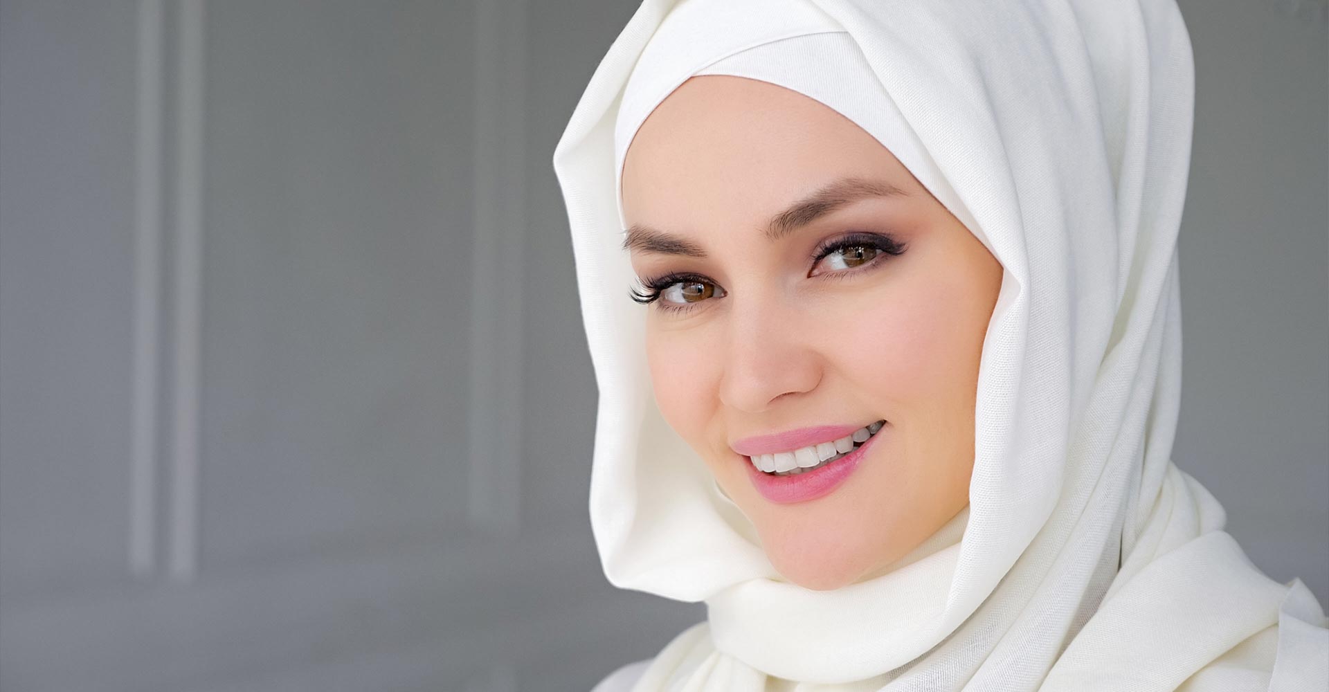 Portrait of muslim arabian woman wearing hijab, looking at camera and smiling